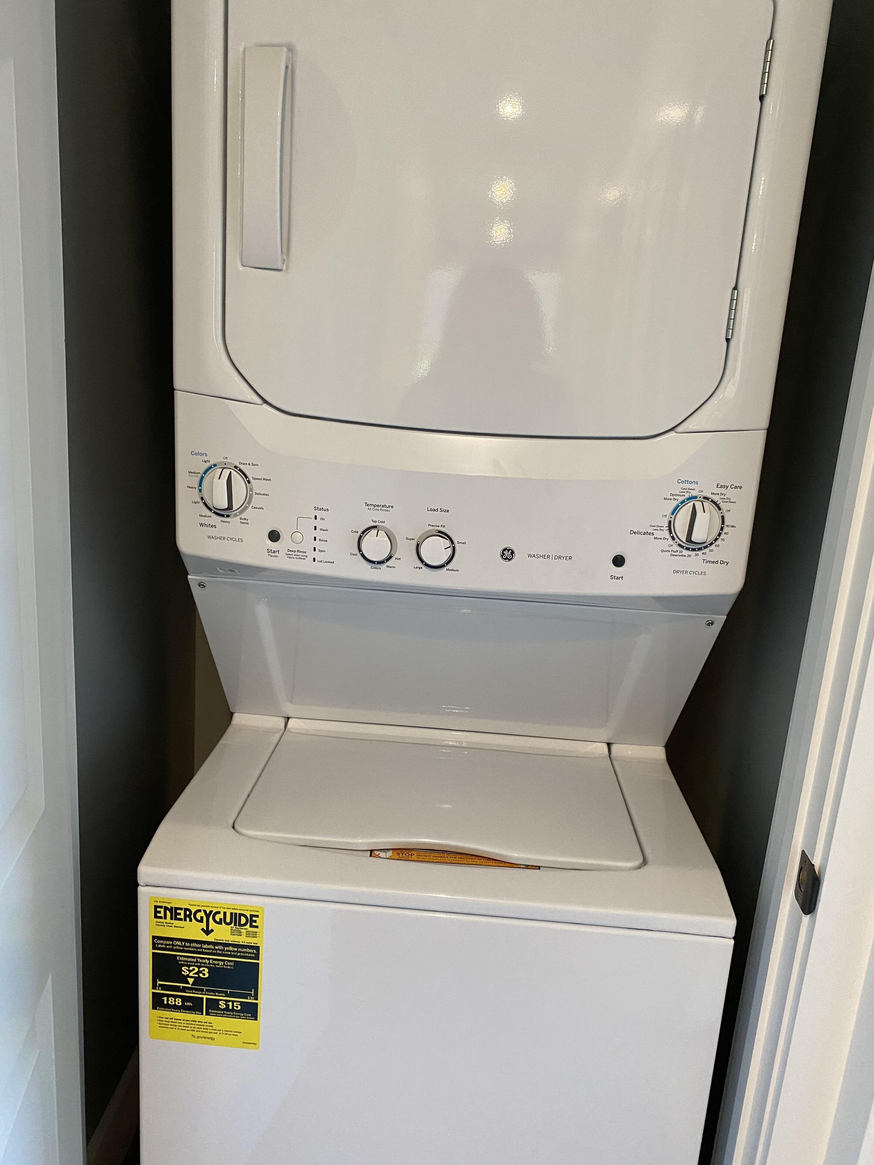 A front view of a white washer and dryer unit with control knobs and an ENERGY GUIDE label.