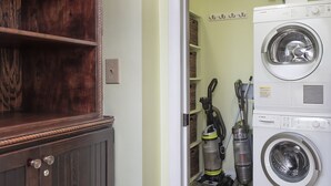 A laundry room with a Bosch washing machine and two vacuum cleaners. - First Floor Ocean View! Pet Friendly! Sleeps 6! Amenity access included! (Seabrook Island)