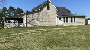 A single-story house with a covered porch, a garage, and a small attached shed.