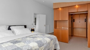 A bedroom with a bed, a bedside lamp, a wardrobe, and a door leading to another room. - Apartment Sturm by Interhome (Warwerort)