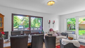 En matplats med ett bord för fyra personer, en soffa och ett fönster med utsikt över omgivningen.