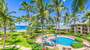 A resort with a pool, palm trees, and a view of the ocean. - Turtle Bay Villas 308 by Gather: Beachfront w/ Shared Pool/Spa/AC (Kahuku)