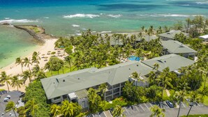 An aerial view of a resort with a beach, palm trees, and ocean views. - Turtle Bay Villas 310 by Gather: Beachfront w/ Shared Pool/Spa/AC (Kahuku)