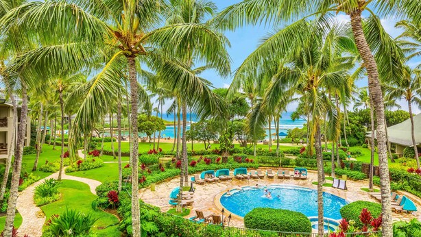 A resort with a swimming pool surrounded by palm trees and lounge chairs. - Turtle Bay Villas 310 by Gather: Beachfront w/ Shared Pool/Spa/AC (Kahuku)