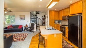 A modern kitchen with wooden cabinets, a black refrigerator, and a built-in microwave. - Wow! Amazing Oceanview, walk to Beach & Game room! (Whitethorn)