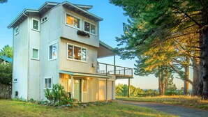 A two-story house with a balcony, surrounded by trees and a grassy yard. - Wow! Amazing Oceanview, walk to Beach & Game room! (Whitethorn)