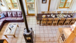 A cozy living room with a fireplace, a dining area with wooden chairs, and a sofa. - Spacious chalet La Tania, with half-board (la perriere)