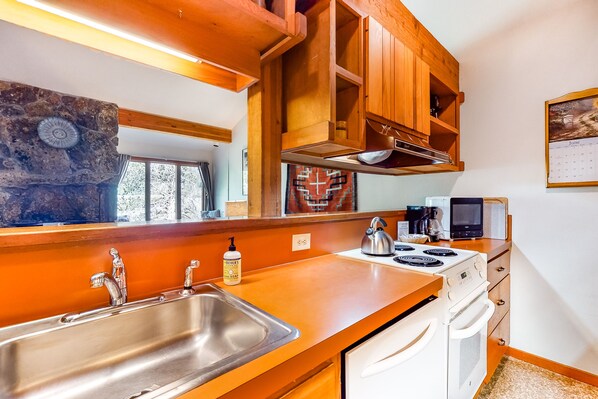 Enjoy cooking in this kitchen with an oven and wooden cabinetry.