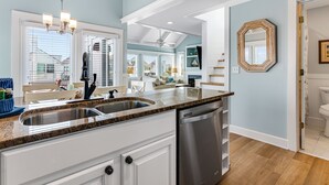 A modern kitchen with granite countertops, stainless steel appliances, and a view to the dining area.