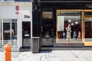 A storefront with a black facade, a large window display, and a visible fire hydrant. - Hausd - Floral Street (London)