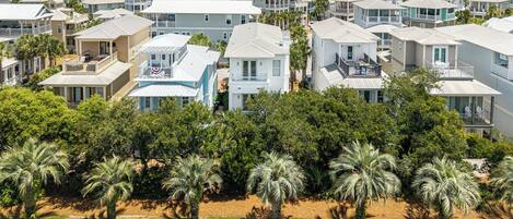 Zona residencial con varias casas de dos pisos, un sendero pavimentado y palmeras.
