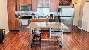 A modern kitchen with wooden cabinets, stainless steel appliances, and a granite countertop.