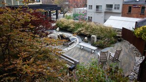 A rooftop garden with outdoor seating and a pergola.