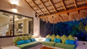 A cozy seating area with a green sofa and blue cushions, a wooden table, and a large mirror. - Private Villa w/Pool Heat option Near Akumal/Tulum (Akumal)