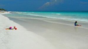 A beach with a child playing, a clear sky, and calm waters. - Private Villa w/Pool Heat option Near Akumal/Tulum (Akumal)
