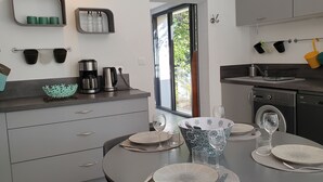 Een moderne keuken met een eethoek, met een koffiezetapparaat, waterkoker en een spoelbak.