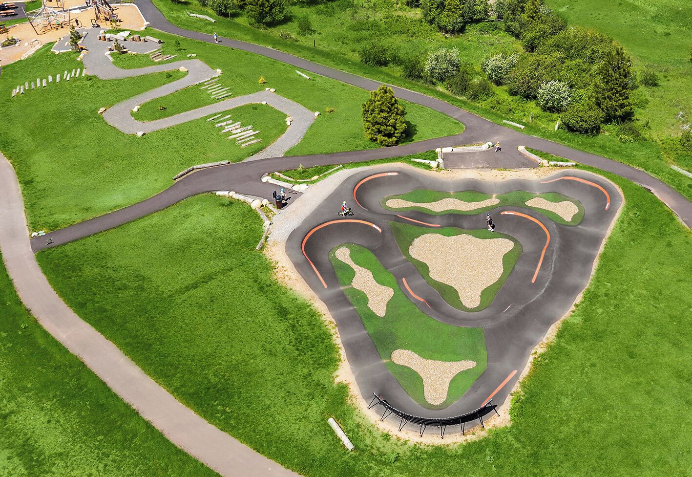 Vue aérienne d’un parc avec des allées sinueuses, une zone en forme de cœur et une aire de jeux.