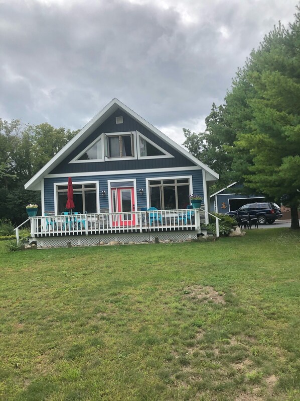 A two-story house with a porch, a garage, and a driveway. - Heavenly Lakeside Retreat (East Jordan)