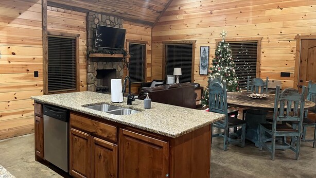 A cozy cabin interior with a kitchen, dining area, and a fireplace. - Dancing in the Moonlight - Walking Distance to New CASINO (Broken Bow)