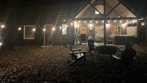 A log cabin with a large porch, outdoor seating, and a Christmas tree. - Dancing in the Moonlight - Walking Distance to New CASINO (Broken Bow)