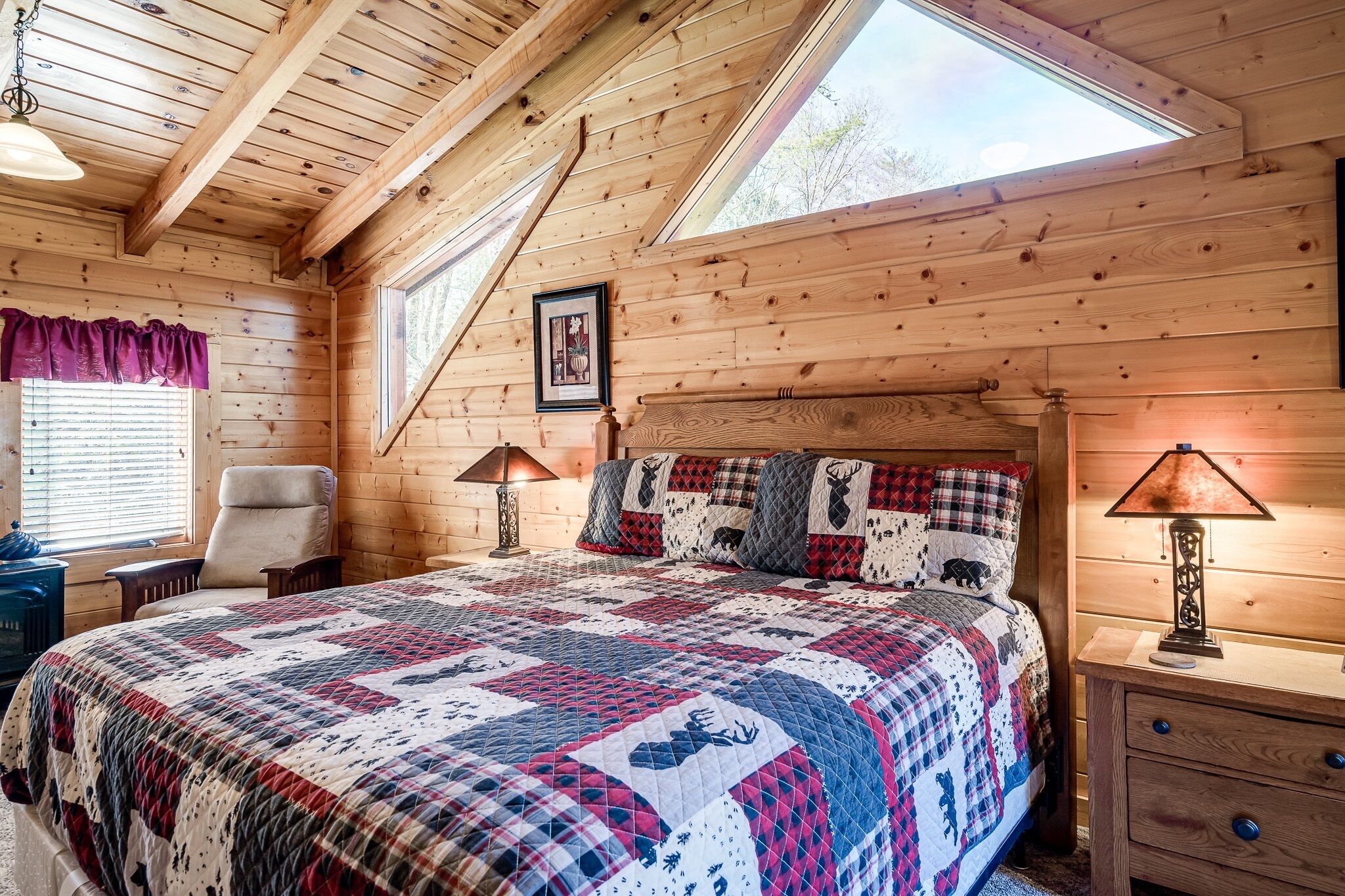 Une chambre confortable avec un grand lit, une chaise, une table de chevet et une fenêtre donnant sur l’extérieur.