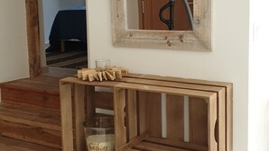 A wooden shelf unit with a candle and a glass container, a wooden door frame, and a thermostat on the wall. - Village house, sleeps 8.  (Saint-Chaffrey)