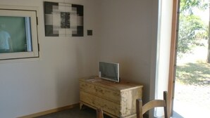 A room with a wooden dresser, a chair, and a window with a view of the outdoors. - Tourist House San SIsto (Sandrigo)