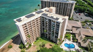 A high-rise hotel with multiple floors, a rooftop pool, and solar panels. - Check out our Summer Discounts and Fantastic Views! (Lahaina)