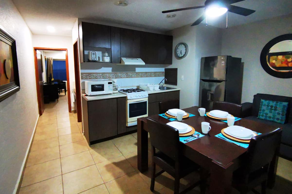 Apartamento luxo, 2 camas de casal, vista parcial para o mar | Cozinha privada | Geladeira, micro-ondas, fogão, talheres/pratos/utensílios de cozinha