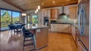 A modern kitchen with wooden cabinets, stainless steel appliances, and a large island with bar stools.