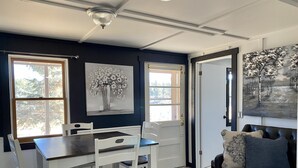 Una zona de menjador amb taula i cadires, un sofà i obra d'art a les parets.