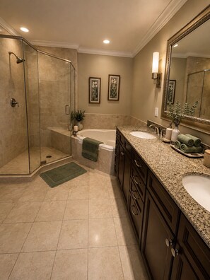 Une salle de bain avec une douche à parois de verre, une baignoire, deux lavabos et un grand miroir.