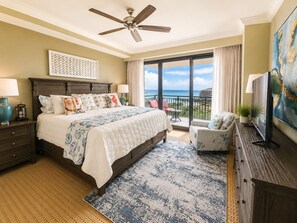 Ein Schlafzimmer mit einem großen Bett, einem Deckenventilator, einem Fernseher und einem Balkon mit Blick.