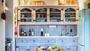 Eine Küche mit Holztisch, Spüle und Kühlschrank.