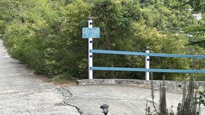 A pathway leading to a gate with a sign reading "lots of nuts." - NEW FOR THIS SEASON BACK UP BATTERIES. NO WAPA NO PROBLEM (St John)
