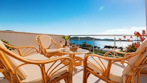 A balcony with wicker furniture and a view of the sea. - Beach front home in Zaboric (Zaboric)