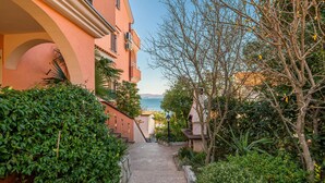 Un sentiero stretto che conduce a un edificio con vista sul mare.