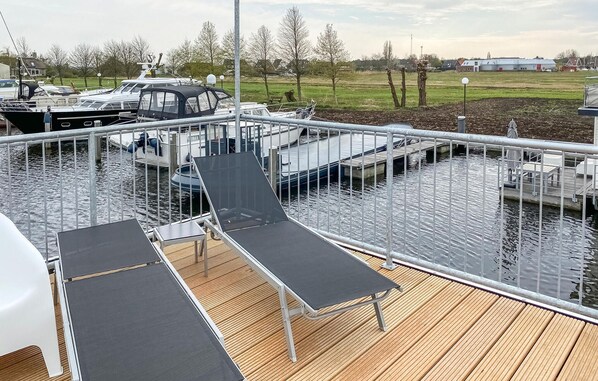 A deck with two sun loungers and a view of boats docked at a marina. - Lovely ship in Aalsmeer with lake view (Aalsmeer)