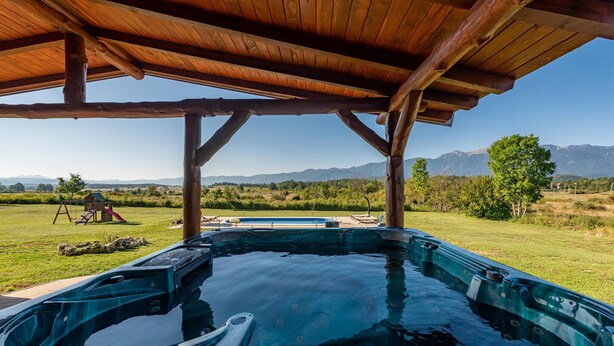 A hot tub under a wooden pergola with a view of mountains and a grassy field. - Amazing home in Sveti Rok (Sveti Rok)