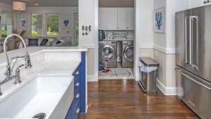 A modern kitchen with a stainless steel refrigerator, a built-in washing machine, and a large sink. - Luxury Getaway on Bald Head Island - 5-Star Property - Discounts for September (Bald Head Island)