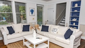 A living room with a white sofa set, a coffee table, and a blue wall shelf. - Luxury Getaway on Bald Head Island - 5-Star Property - Discounts for September (Bald Head Island)
