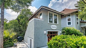 A two-story house with a covered porch, a garage, and a sign that reads "DREAMSTEAD BEACH HOUSE." - Luxury Getaway on Bald Head Island - 5-Star Property - Discounts for September (Bald Head Island)