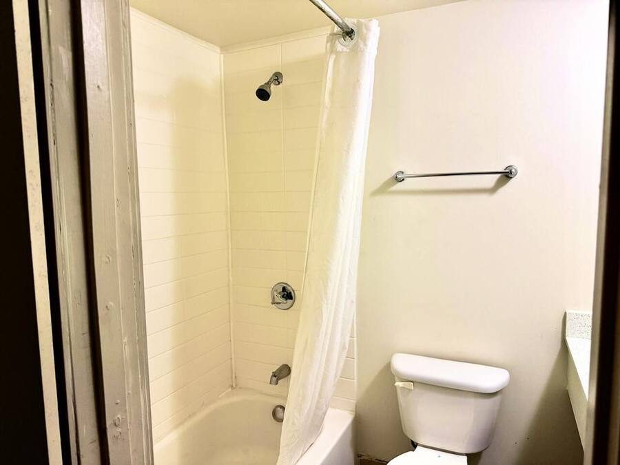 A bathroom with a bathtub, shower, and toilet.