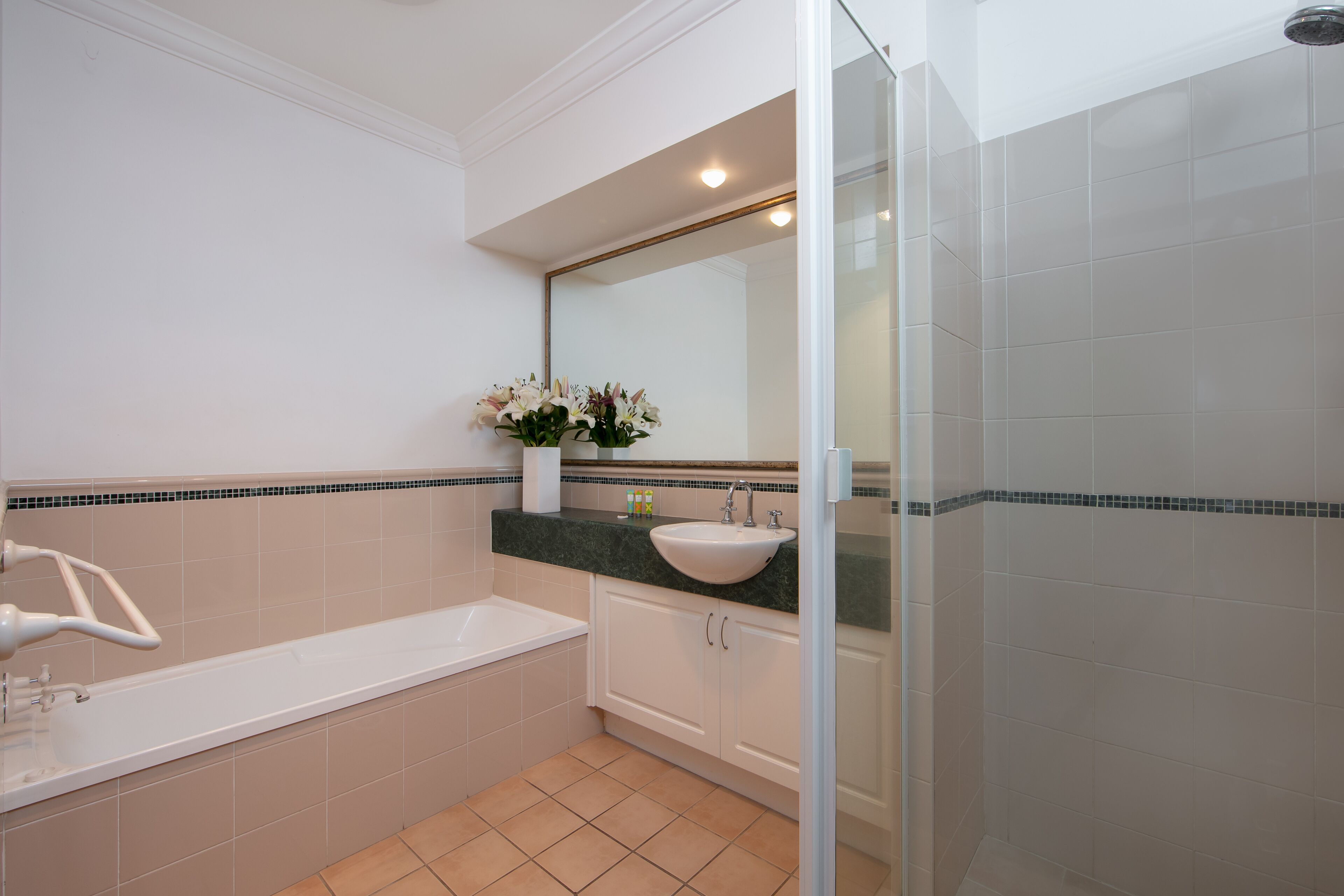 A modern bathroom with a bathtub, a sink, and a shower area.