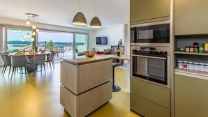 Ett modernt kök med inbyggd ugn, mikrovågsugn och en matplats med utsikt.