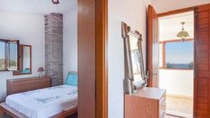 Un dormitorio con cama, cómoda, espejo y balcón con vistas.