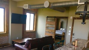A compact living space with a sofa, a small table, and a kitchenette area. - In the Heart of Downtown Historic Hot Springs (Hot Springs)
