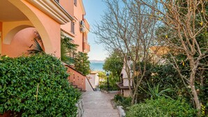 A narrow pathway leading to a building with a view of the sea. - Awesome apartment in Njivice with WiFi (Njivice)