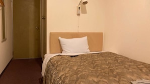 A single bed with a headboard, a white pillow, and a patterned bedspread. - Business Hotel Chateau Est Takamatsu (Takamatsu)