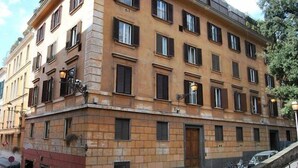 Um edifício de vários andares com estilo arquitetônico uniforme, com janelas regularmente dispostas e uma entrada central.